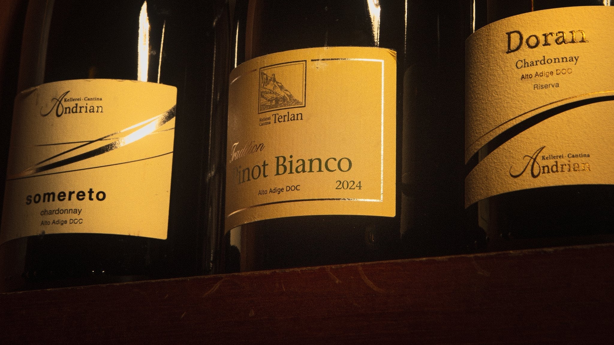Rótulos de vinhos brancos do Alto Adige na prateleira da adega