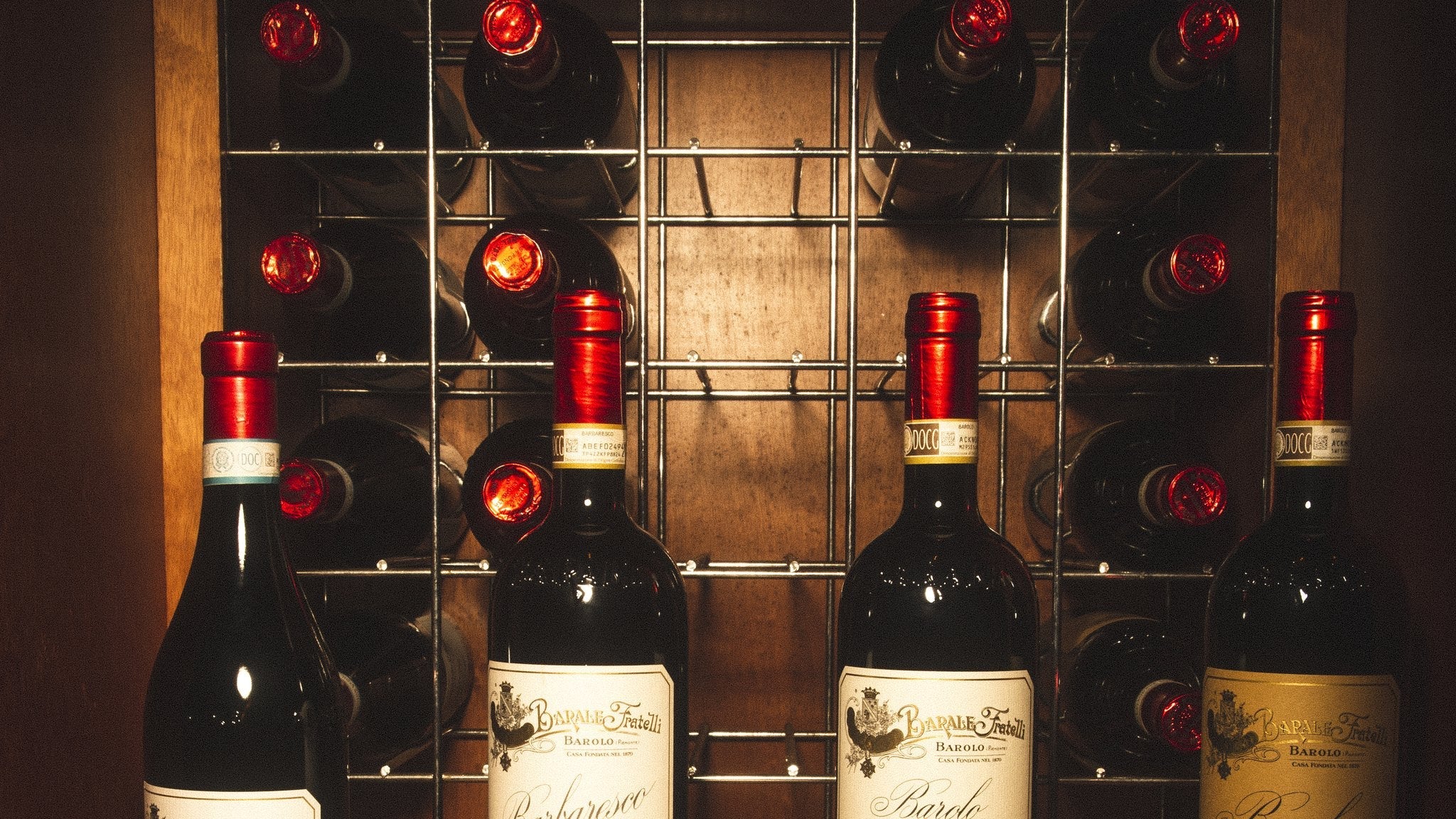 Garrafas de tinto Barale Fratelli em nicho de madeira na adega